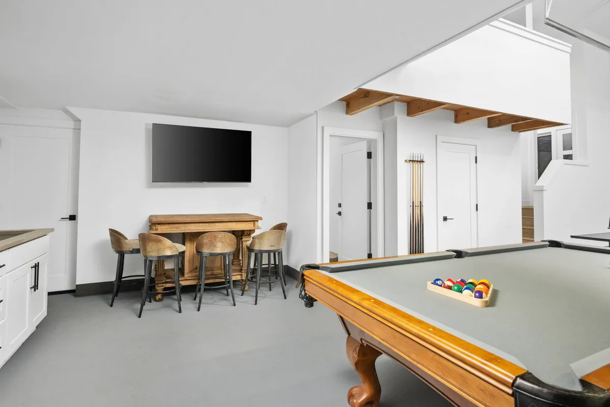 A lively interior featuring a pool table, bar area, and a large television, set up for socializing, gaming, and entertainment. The mood is energetic and welcoming, suggesting possibilities for game nights and group celebrations.