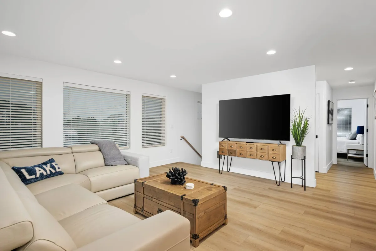 A comfortable and contemporary living room with a plush sofa, coffee table, TV, and decorative plant. The room is bathed in natural light, offering a welcoming space for socializing, watching movies, or relaxing after a day of exploration.